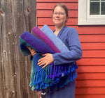 Load image into Gallery viewer, Weaver Emily F Gwynn holding three handwoven blankets 
